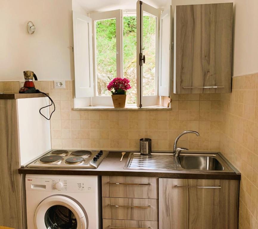 a kitchen with a sink and a washing machine at Casetta romantica a Collepardo in Collepardo