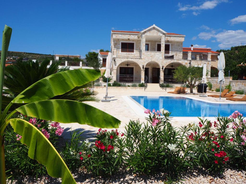 una casa grande con un patio con piscina en Villa Ludilo mit 4 Apartments in Poljica - Marina bei Trogir Split, en Poljica
