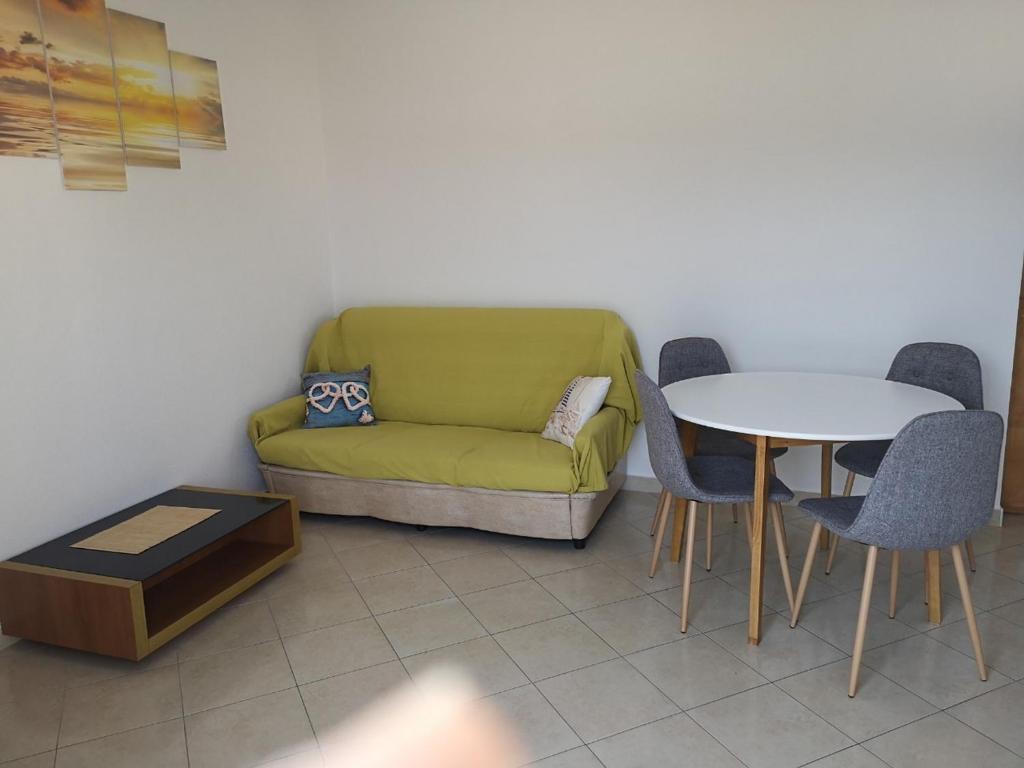 ein Wohnzimmer mit einem grünen Sofa und einem Tisch in der Unterkunft Apartment Marta in Rab