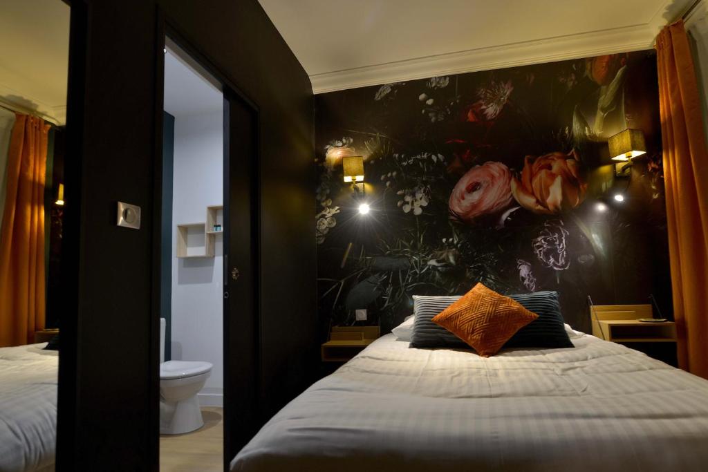 a bedroom with a bed with a flower wall at Hôtel Le Tiburon in Cherbourg en Cotentin