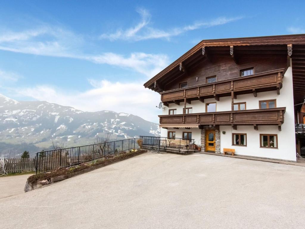 a building with a balcony with mountains in the background at Wooden apartment in Hart with terrace in Großhartberg