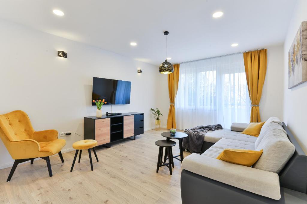 een woonkamer met een bank en stoelen en een tv bij Zara Lumina Apartment in Zadar