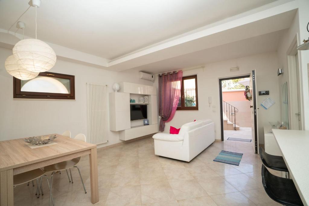 sala de estar con sofá blanco y mesa en La Casetta di Chiara B&B, en Polignano a Mare