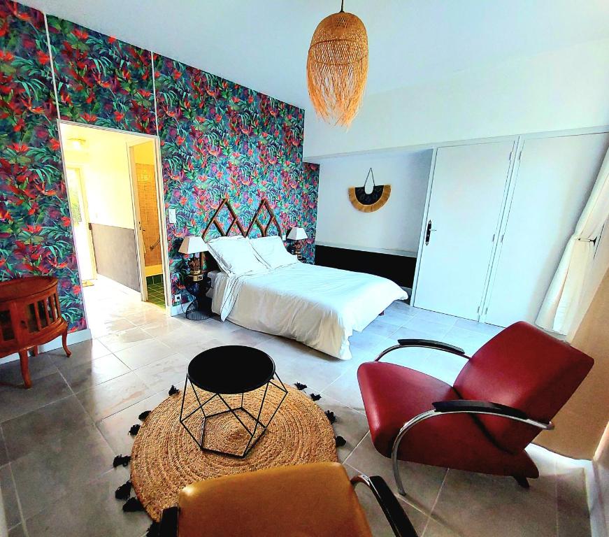 une chambre avec un lit, une table et des chaises dans l'établissement Chbre Frida du Chateau, avec Piscine, à Peyriac-Minervois