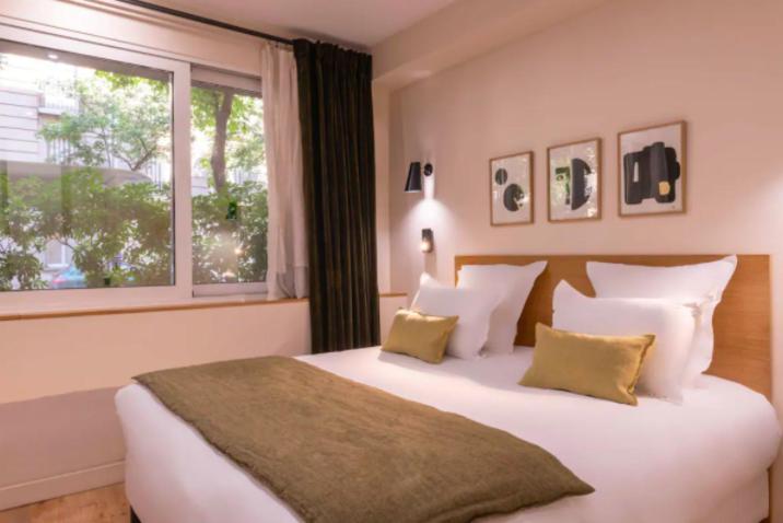 une chambre avec un grand lit blanc avec une fenêtre dans l'établissement Magnificent apartment - 2BR-7P - Auteuil, à Paris