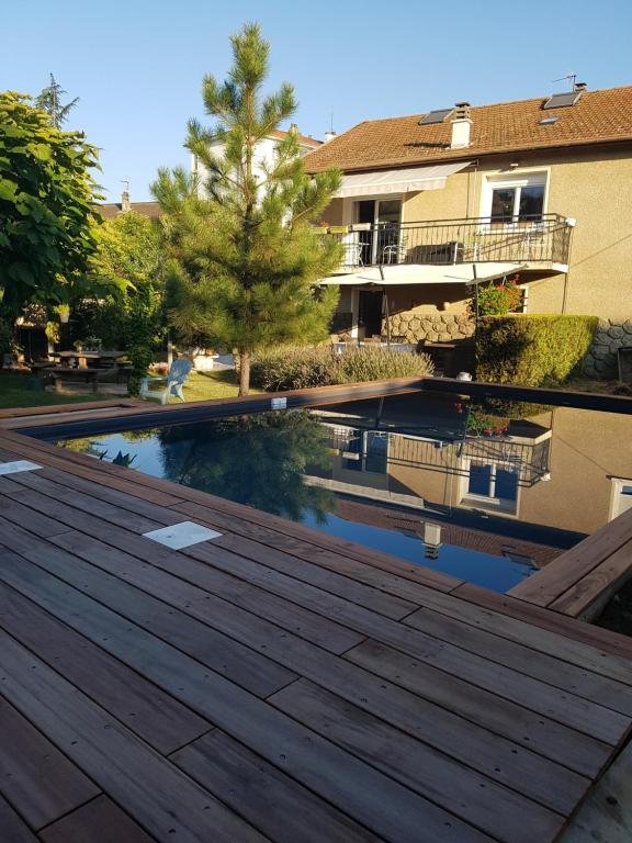 uma vista do deque de um edifício com piscina em Chambre d'hôtes Le Cyprès Bleu em Roussillon en Isere