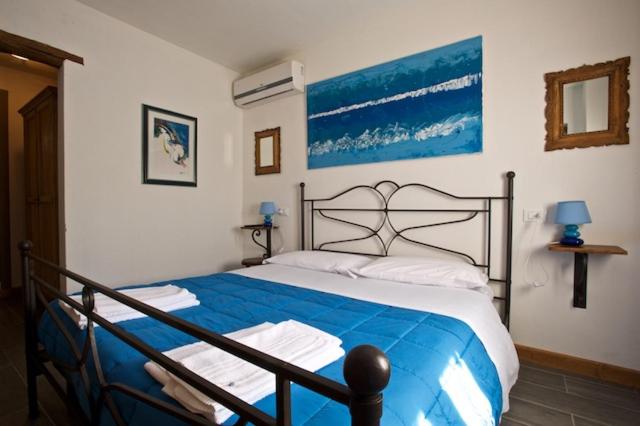 1 dormitorio con 1 cama con sábanas azules y blancas en Le Perine 6, en Valdobbiadene