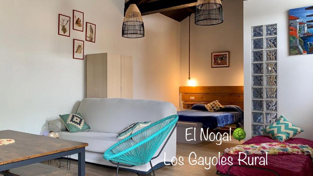 uma sala de estar com um sofá e uma cama em Estudio Pajar rural con bonito jardín - Los Gayoles Rural em Castropol