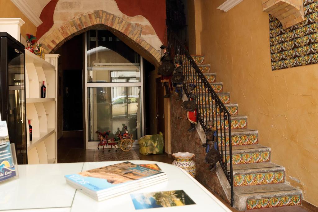 トラーパニにあるCase Vacanze Benvenuti al Sudの螺旋階段の横のカウンターに座る本