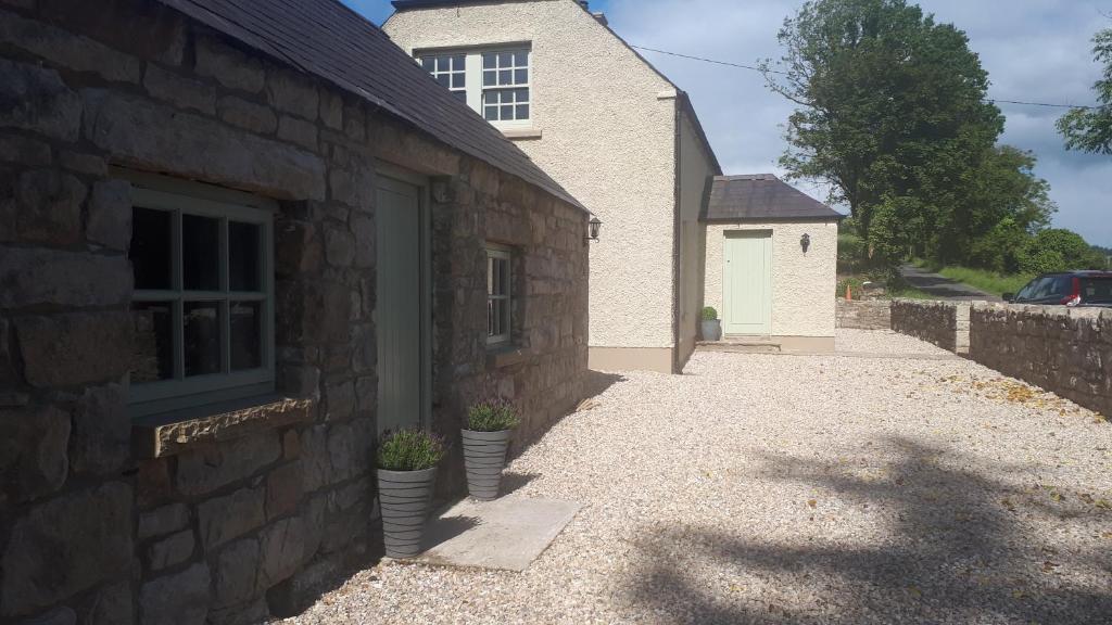 un edificio di mattoni con due piante in vaso accanto a una porta di Herds House Belcoo a Belcoo