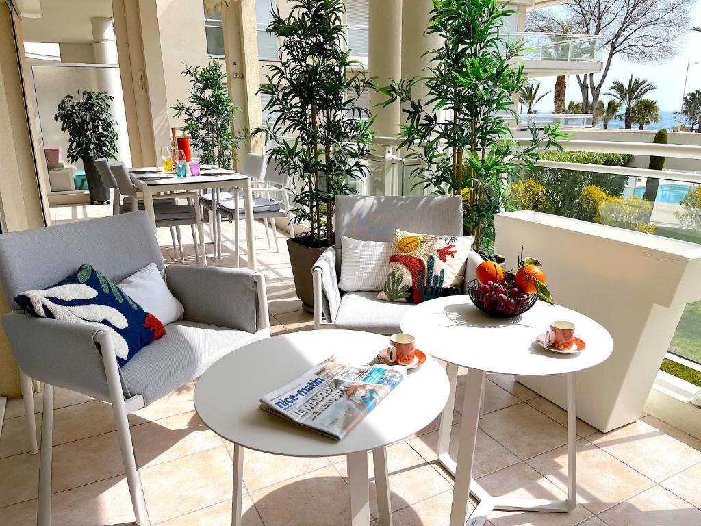 d'une terrasse avec 2 tables et 2 chaises. dans l'établissement L'appartement Royal Palm, à Cannes