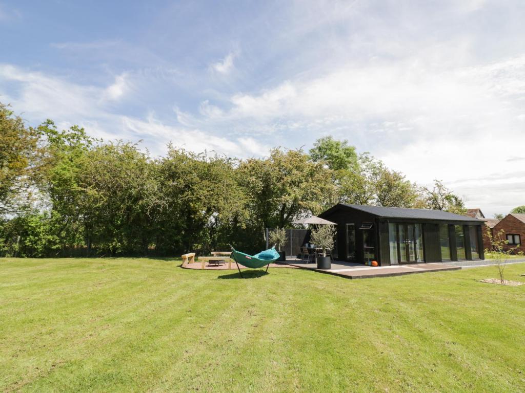 a house in a field with a green yard at The Tractor Shed in Worcester