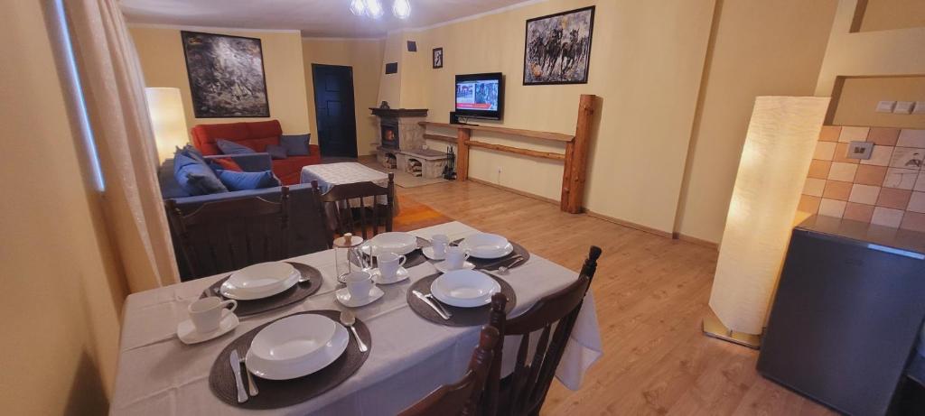 uma sala de jantar com uma mesa e uma sala de estar em Apartament Alcatraz z kominkiem Kamienna Góra em Kamienna Góra
