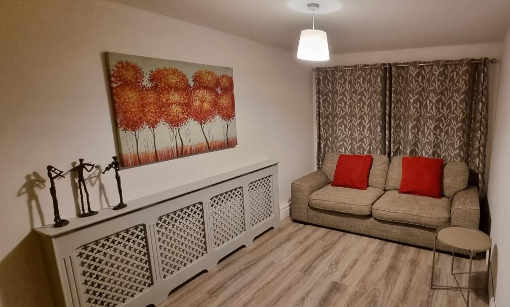 a living room with a couch and a painting on the wall at Spacious Curragh 2-bed apartment with own entrance in Brownstown Cross Roads