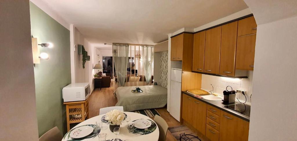 a kitchen with a table and a room with a bed at Bahia 1-5-74 Apt face mer, marina d empuriabrava in Empuriabrava