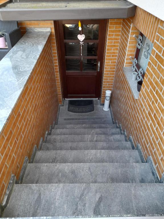 un conjunto de escaleras que conducen a una puerta de madera en Zimmervermietung Bully, en Meyenburg