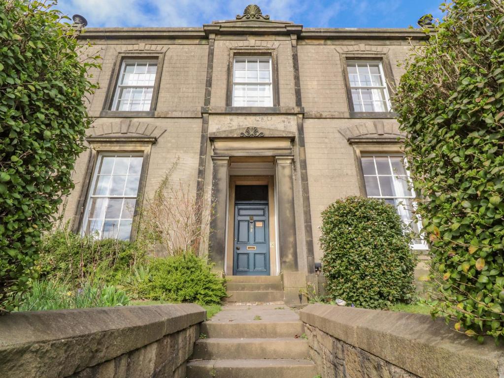 an old brick building with a blue door at Windyridge in Settle