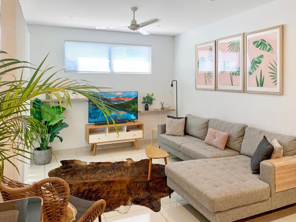 een woonkamer met een bank en een tv bij Darwin City Chic@Kube Apartments in Darwin
