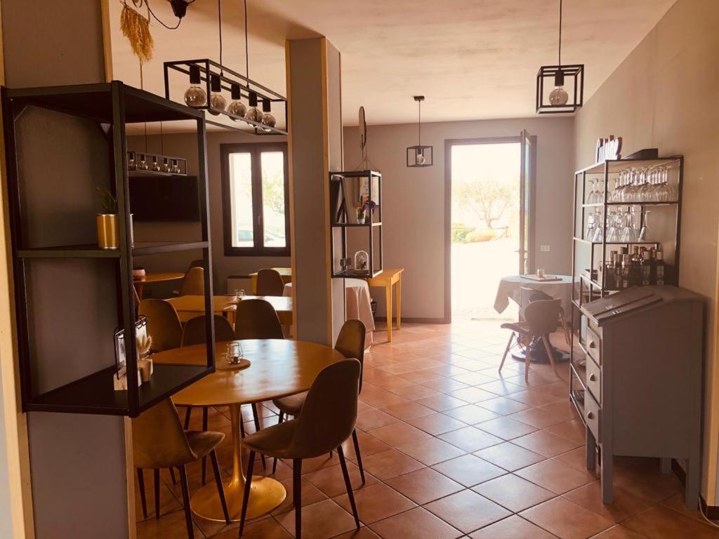 een keuken en eetkamer met een tafel en stoelen bij Locanda delle grotte di Onferno in Gemmano