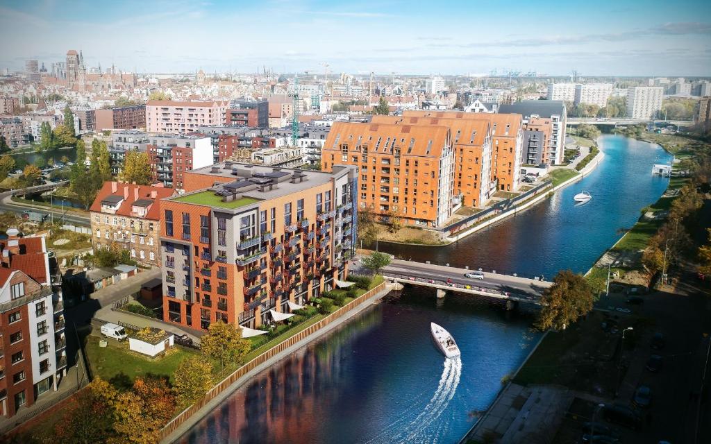 une vue aérienne sur une ville avec une rivière et des bâtiments dans l'établissement Dwie Motławy Apartinfo Apartments, à Gdańsk