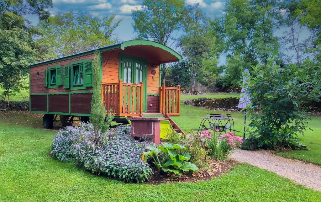 une petite maison au milieu d'un jardin dans l'établissement Les Roulottes du Petit Gouffre de Padirac, à Padirac