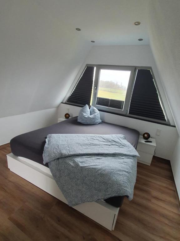 1 dormitorio con cama y ventana grande en Bigge Huus Ferienhaus, en Olpe