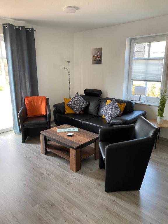 sala de estar con sofá y mesa de centro en Ferienhaus „Kleinheide 18”, en Großheide