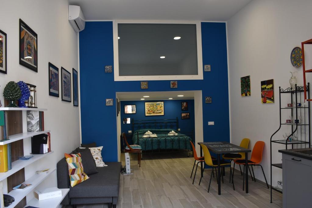 a room with a blue wall with a bed and a table at atocà1 casa vacanze - vedi anche atocà2 e atocà3 in Palermo