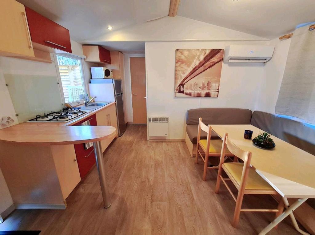 a kitchen and living room with a table and a couch at L'éveil des sens in Saint-Chéron