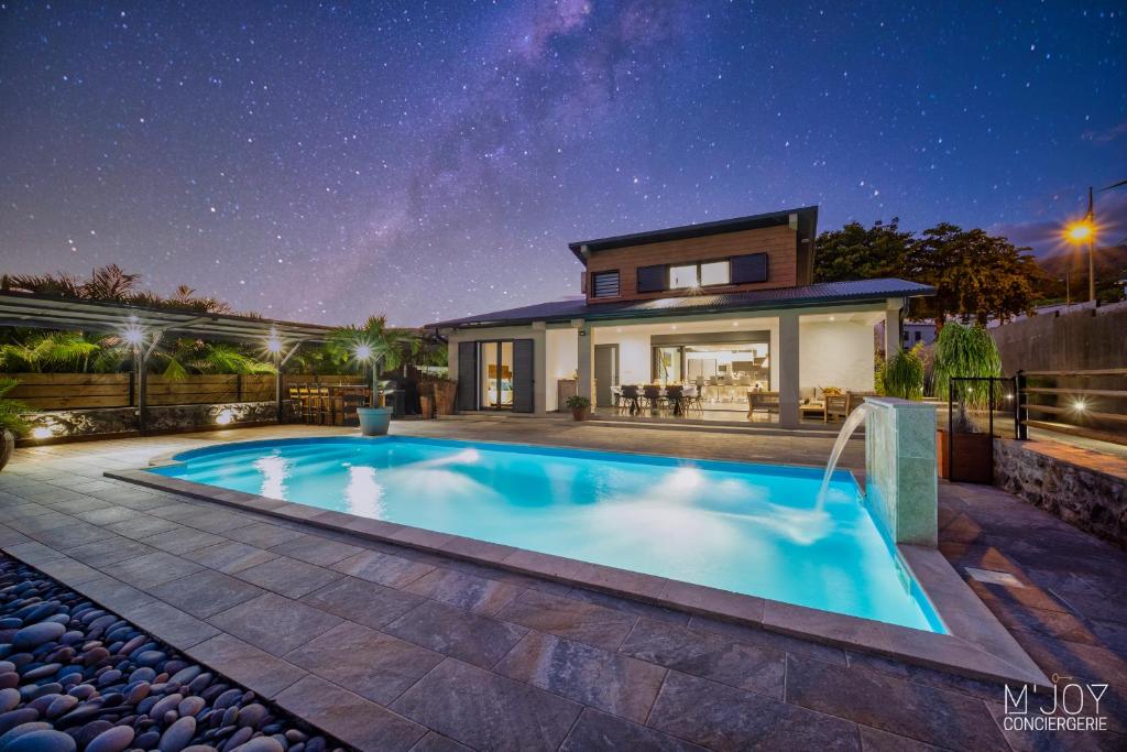 una casa con piscina por la noche en VILLA SYLBRIA - Villa d'exception ****, en Étang-Salé