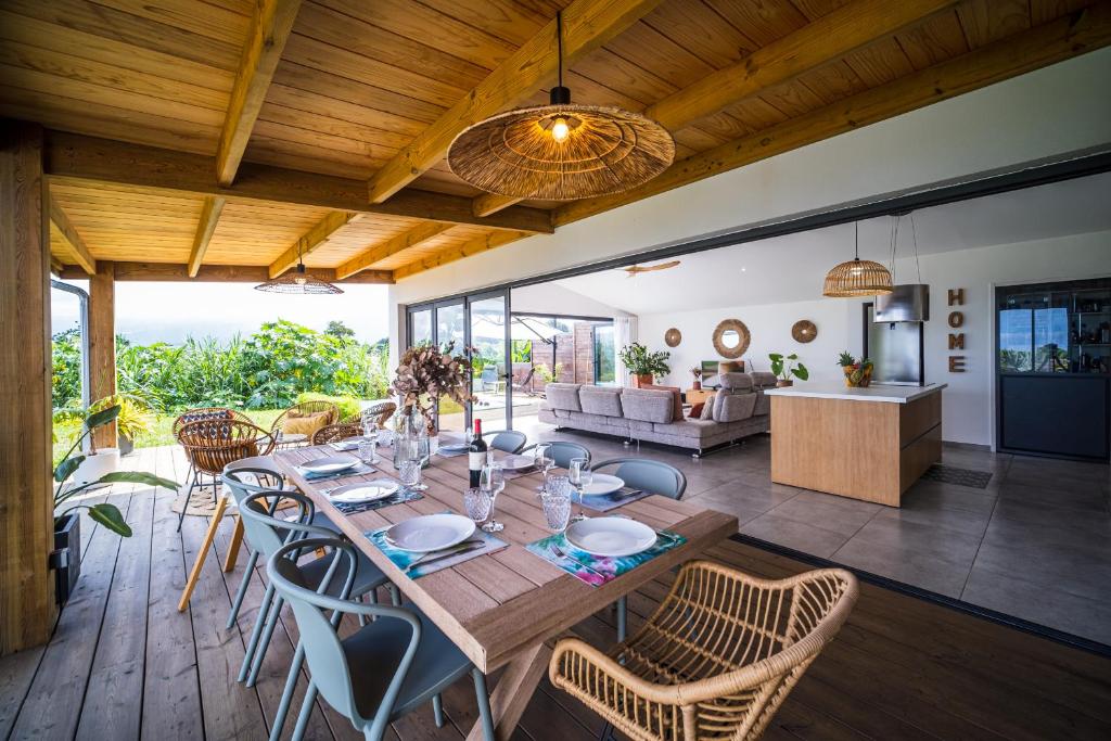 een eetkamer en een woonkamer met een tafel en stoelen bij CASA HAWA - La perle de la Ravine des Cabris in Saint-Pierre