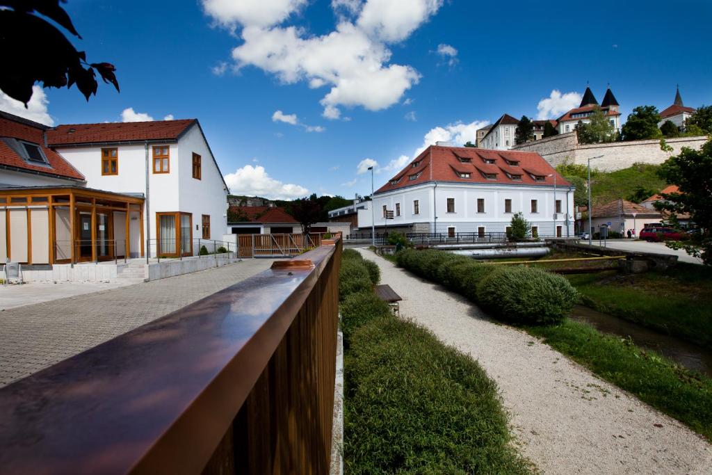 una valla frente a un edificio con casas en Gizella Hotel and Restaurant, en Veszprém