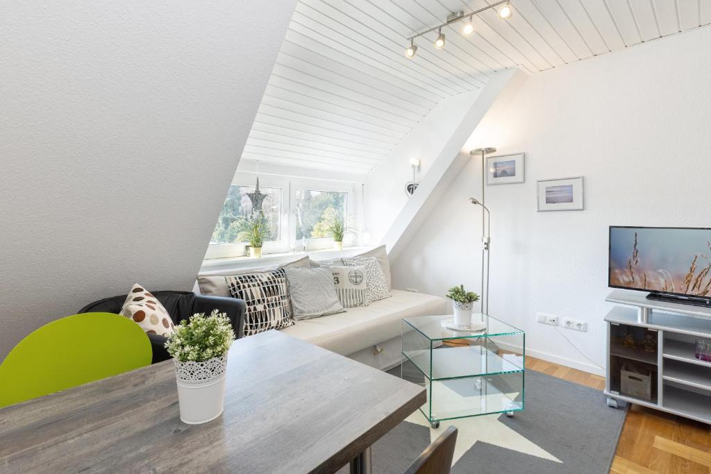 uma sala de estar com uma mesa e um sofá em Haus Waldfrieden Wohnung 1 em Haffkrug