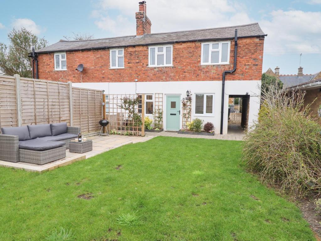 a house with a lawn in front of it at Primrose Cottage in Market Harborough