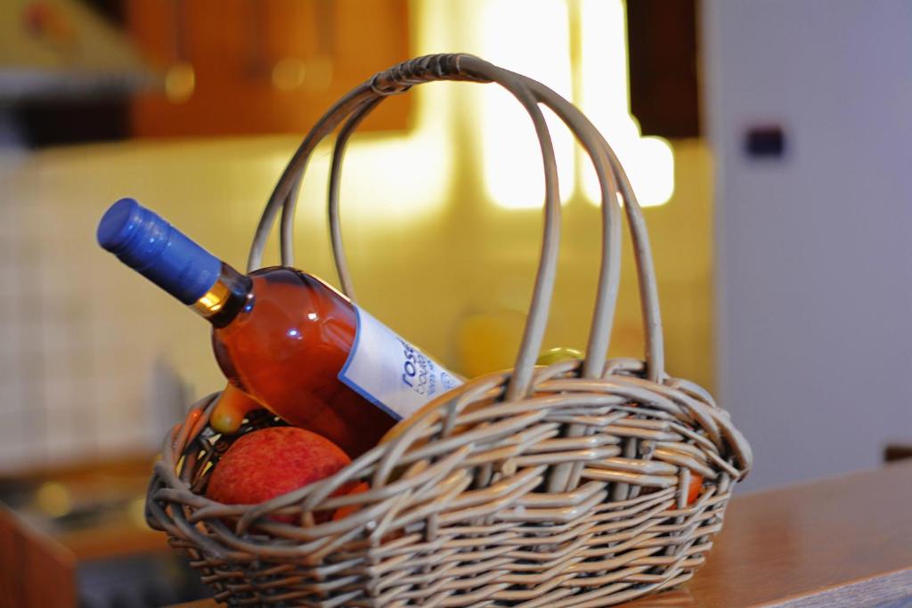 un cesto con una bottiglia di vino e frutta di Moumouri's House a Gastouri