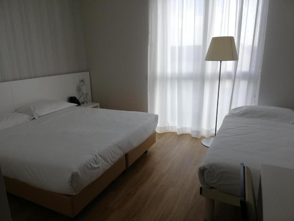 Łóżko lub łóżka w pokoju w obiekcie Novo Hotel Rossi