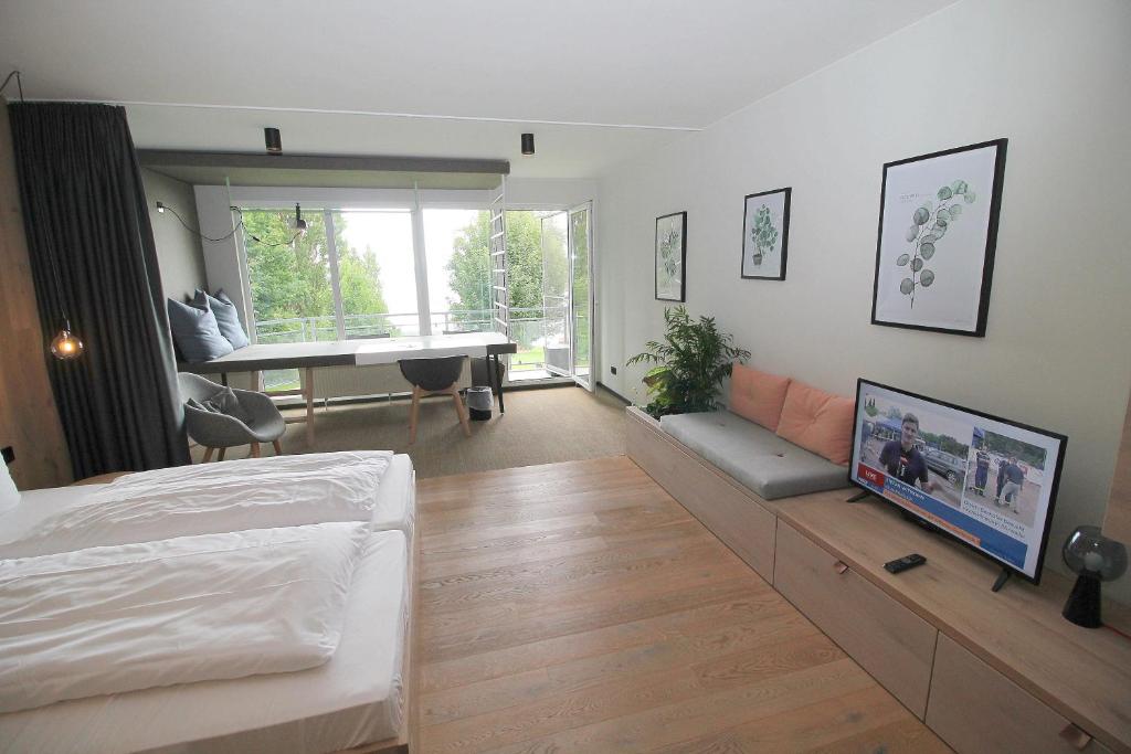 ein Schlafzimmer mit einem Bett und ein Wohnzimmer mit einem Schreibtisch in der Unterkunft Junior-Suite am See in Ascheberg