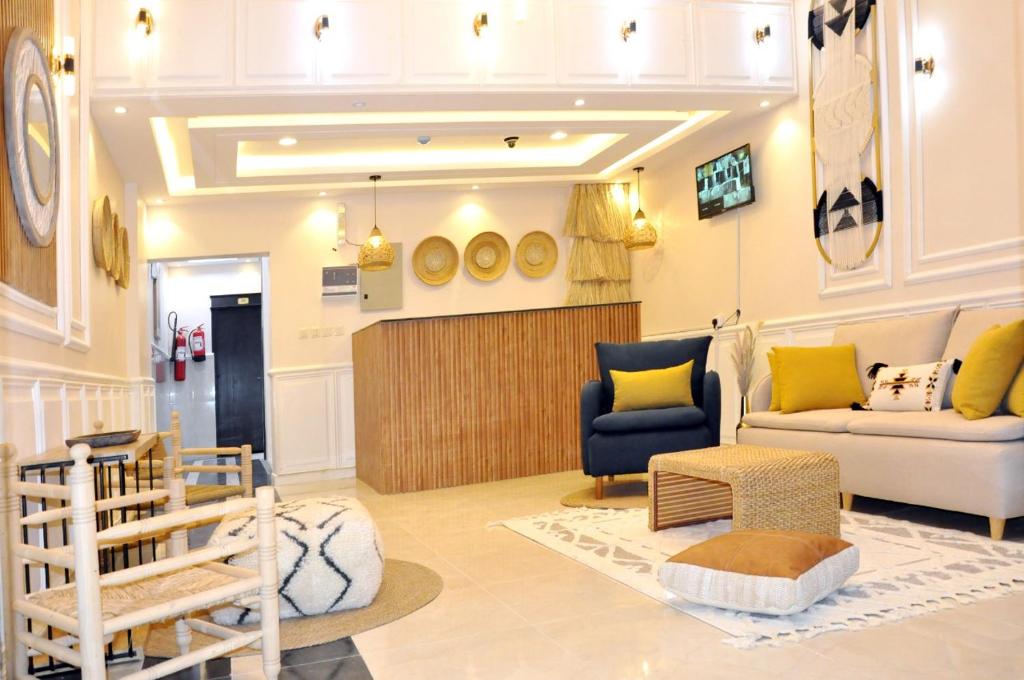 uma sala de estar com um sofá e uma cadeira em Msakn Aldar em Abha