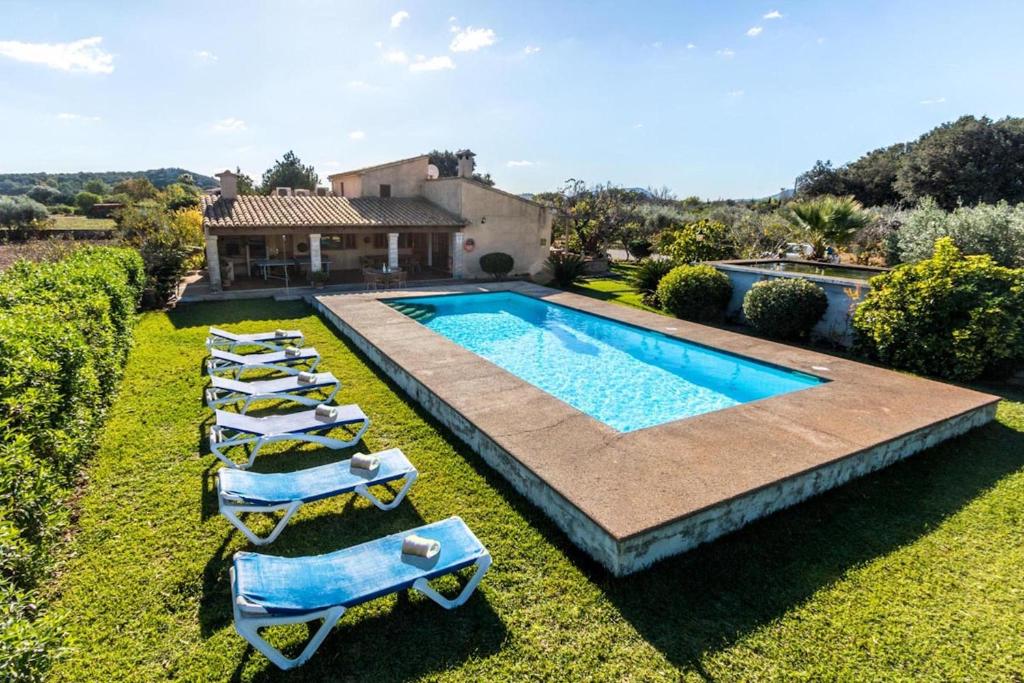 einen Blick über einen Pool mit Liegestühlen und ein Haus in der Unterkunft Fontxica in El Port