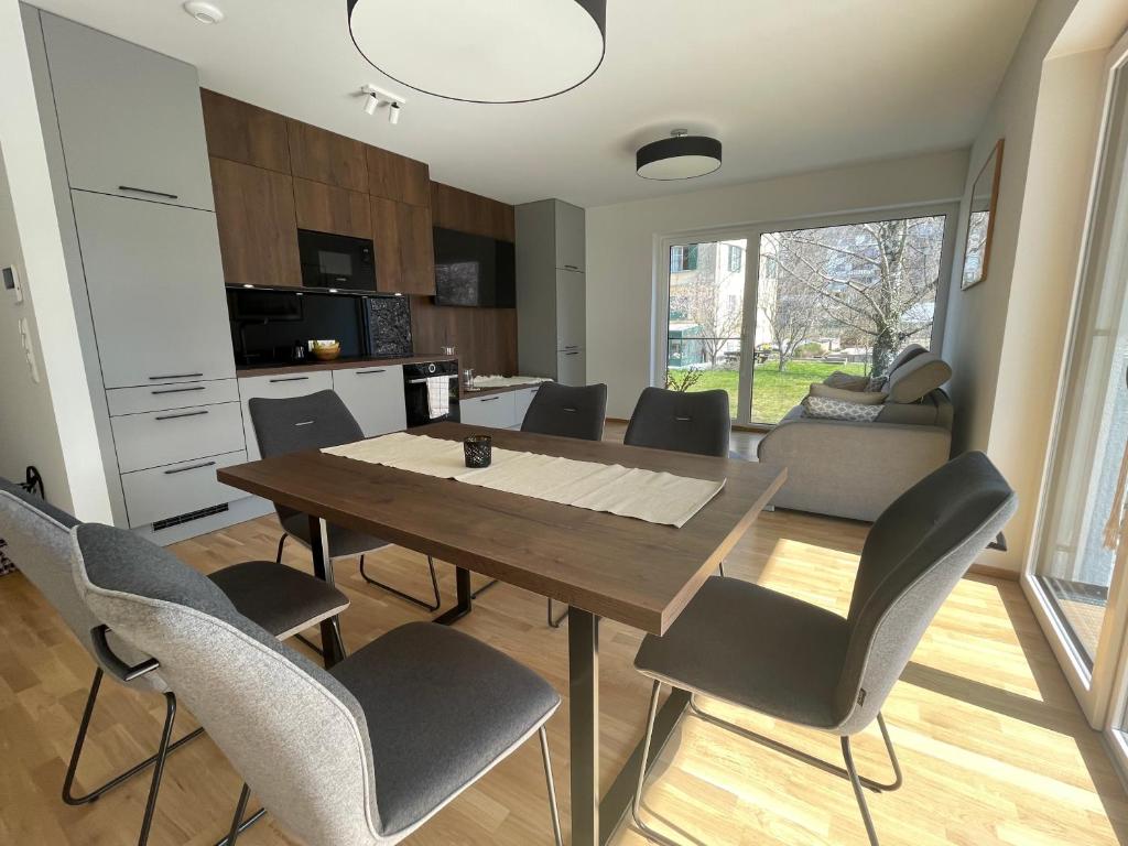 una cucina e una sala da pranzo con tavolo e sedie in legno di Luxury - Apartment mit Balkon in Seenähe a Gmunden