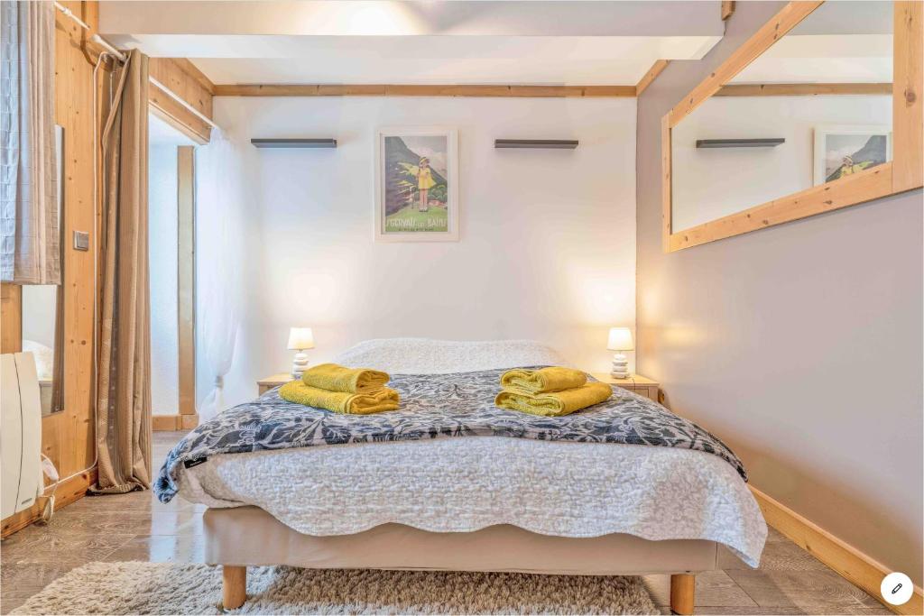 una camera da letto con un letto e due asciugamani di CHAMBRE INDÉPENDANTE avec SALLE DE BAIN INDÉPENDANTE au RDC d un chalet à 25 kms Chamonix a Saint-Gervais-les-Bains