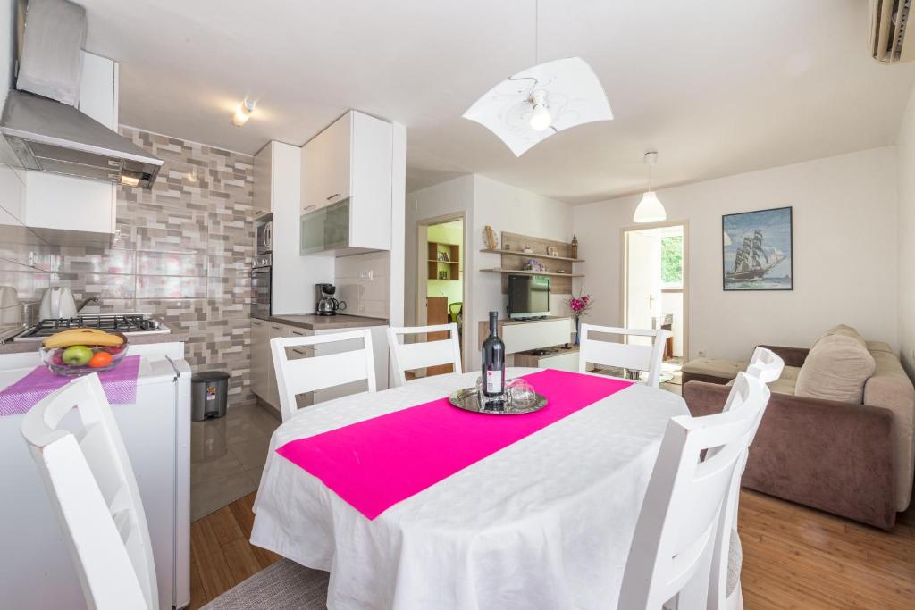 a kitchen and living room with a table with a red table cloth at Apartment Lidija in Dubrovnik