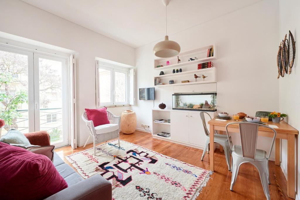 uma sala de estar com uma mesa e uma televisão em Sunny Renovated Apt With AC, By TimeCooler em Lisboa