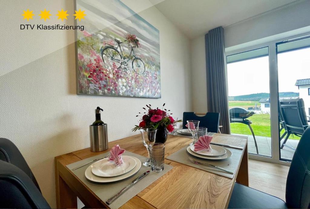 a dining room table with flowers and a painting on the wall at Sonnenweg 46-2 CINDY in Heringhausen