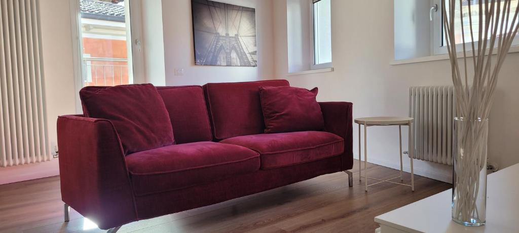 a red couch in a living room with a table at Sarpi21 Suites in Udine