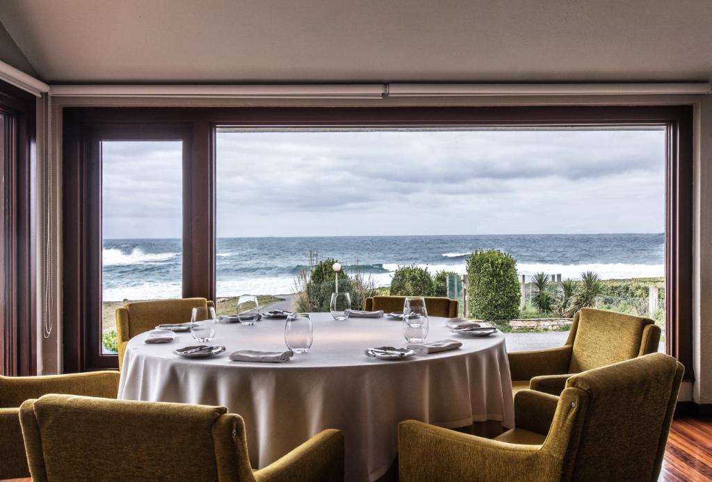 Una mesa en una habitación con vistas al océano en As Garzas, en Barizo