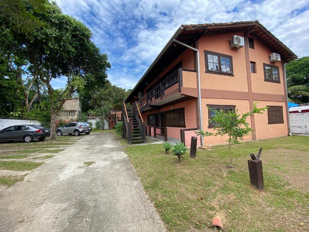 a house with a car parked in front of it at Casa Vento Leste in Ilhabela