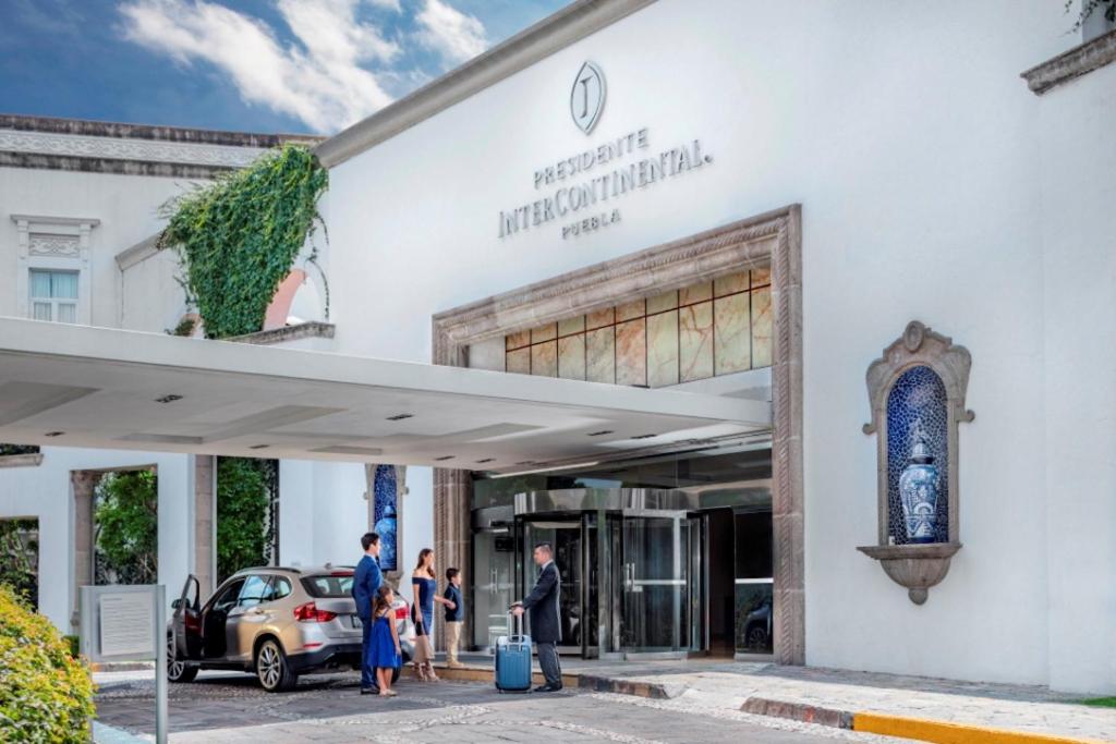 un gruppo di persone che si trovano fuori da un edificio di Presidente Intercontinental Puebla, an IHG Hotel a Puebla