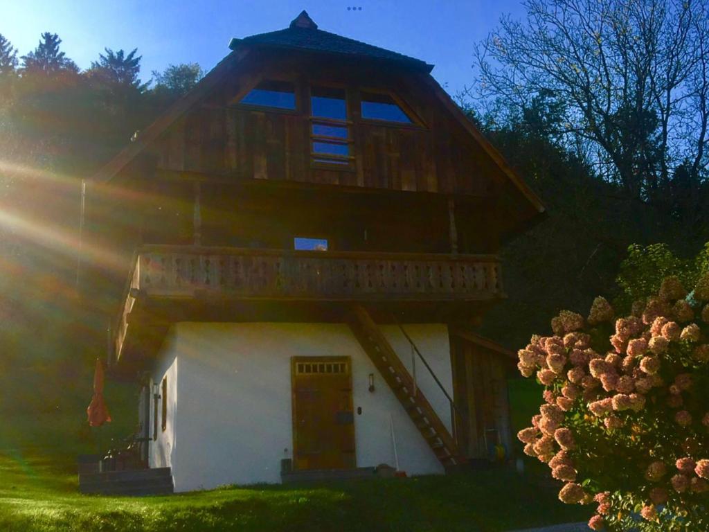 a large wooden house with a gambrel roof at Appartement Kleiner Monde in Weinberg