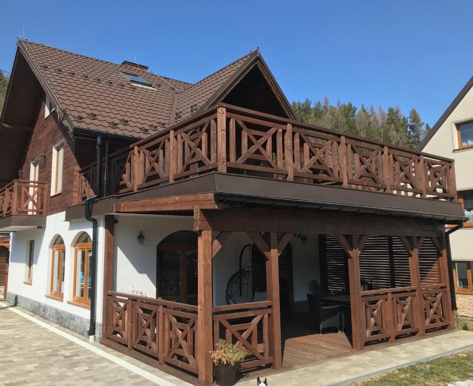 a house with a large deck on top of it at Spiski Zakątek in Niedzica
